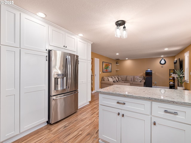 kitchen with white cabinetry, recessed lighting, light wood-style flooring, and stainless steel fridge with ice dispenser