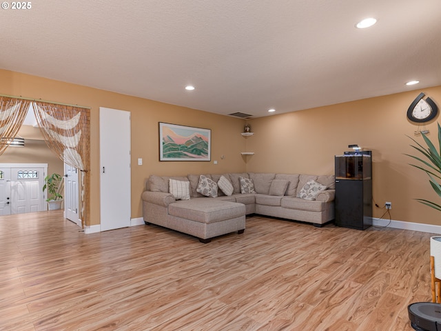 living area with recessed lighting, baseboards, visible vents, and light wood finished floors