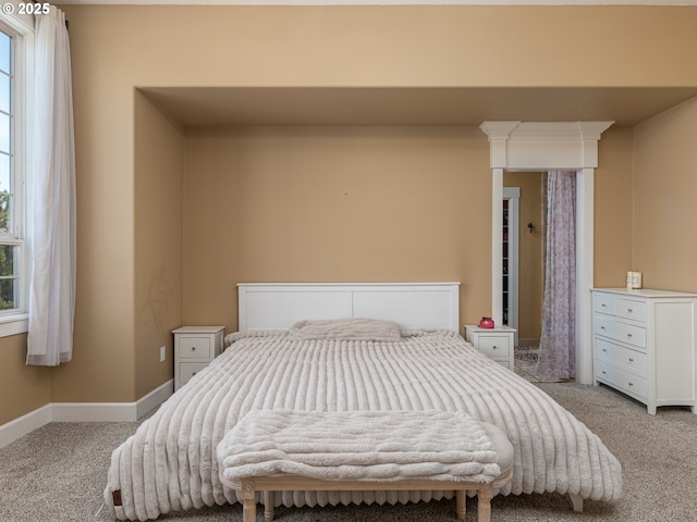 bedroom with baseboards and light carpet