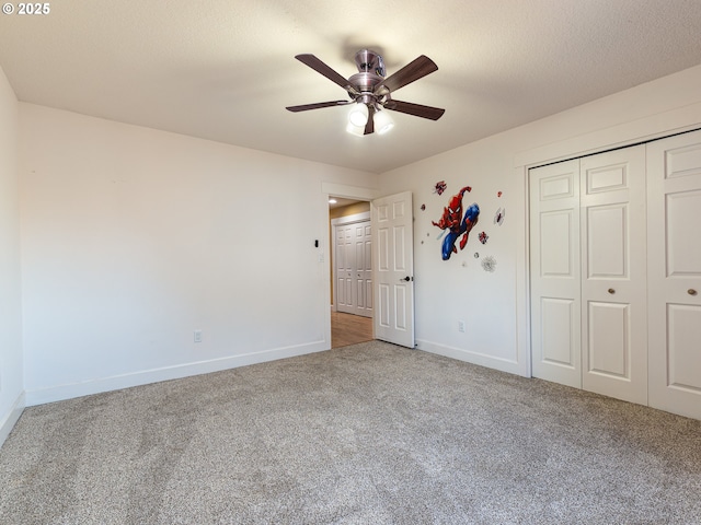 unfurnished bedroom featuring carpet floors, a ceiling fan, baseboards, and a closet