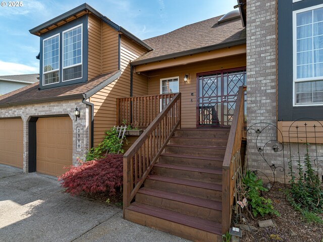 view of front of home featuring an attached garage, a shingled roof, and aphalt driveway