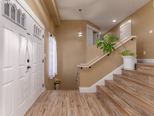 foyer entrance with recessed lighting, baseboards, stairs, and wood finished floors