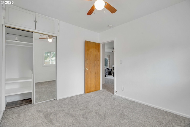 unfurnished bedroom featuring a closet, carpet, a ceiling fan, and baseboards