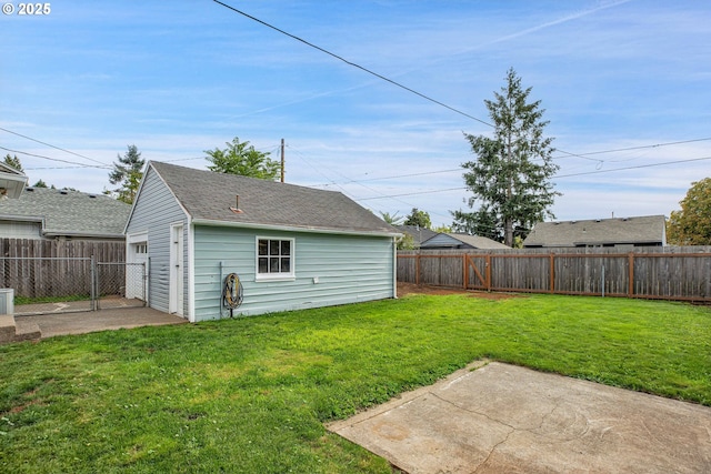 view of yard with a patio area, a fenced backyard, and an outdoor structure