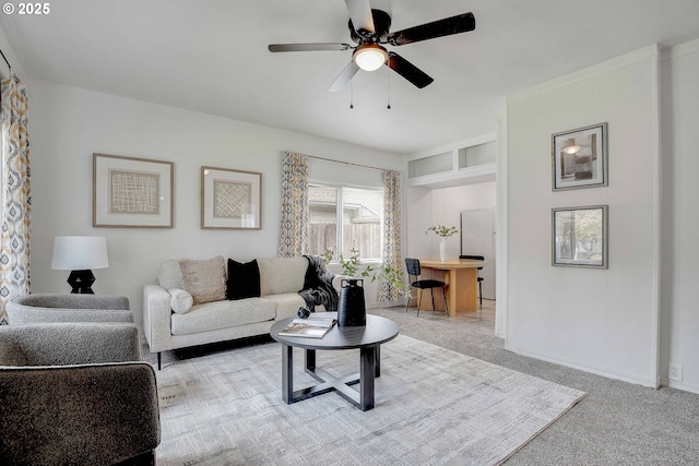 carpeted living area with a ceiling fan