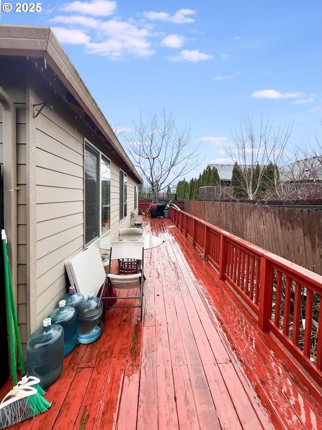 wooden terrace with a fenced backyard