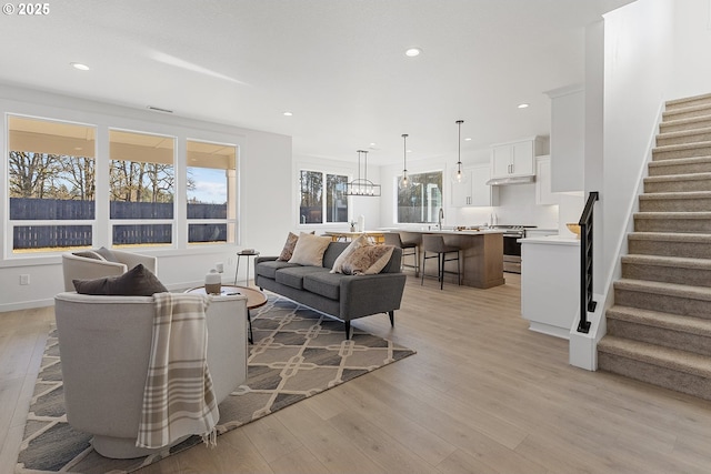 living room with sink and light wood-type flooring