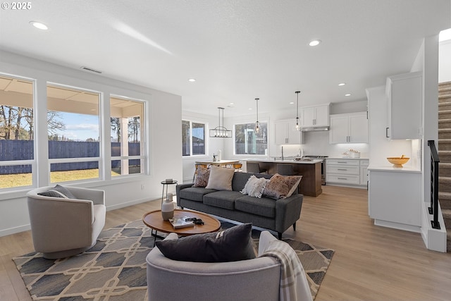 living room featuring sink and light hardwood / wood-style flooring