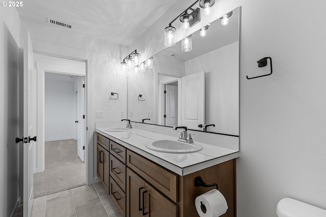 bathroom featuring vanity, tile patterned flooring, and toilet