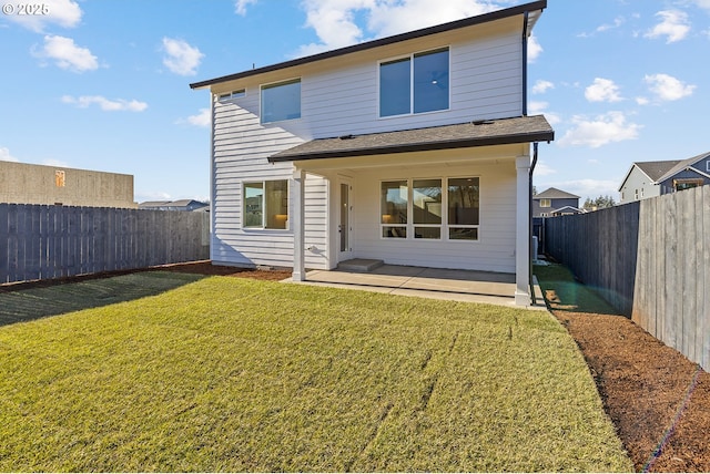 rear view of house with a patio and a lawn