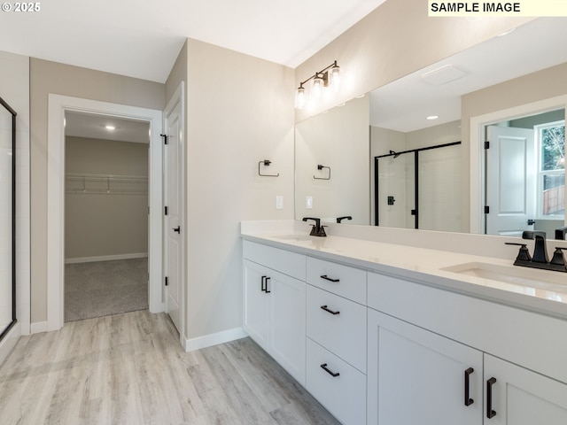 bathroom with an enclosed shower, hardwood / wood-style floors, and vanity