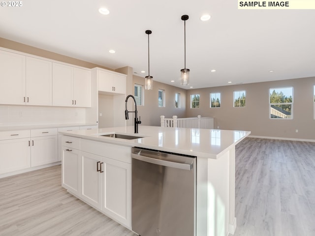 kitchen featuring white cabinetry, dishwasher, sink, and an island with sink