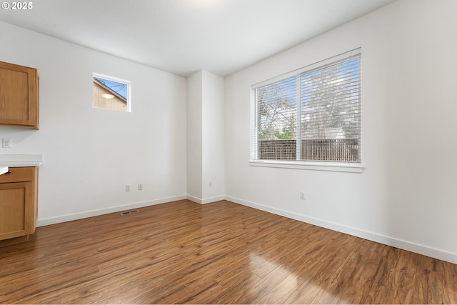 unfurnished dining area featuring wood-type flooring and a healthy amount of sunlight