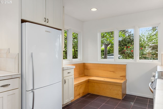 589 Ridgeway Rd, Lake Oswego, OR 97034 - kitchen with freestanding refrigerator, light countertops, white cabinetry, dark tile patterned floors, and recessed lighting