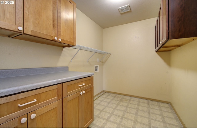 washroom with cabinet space, baseboards, visible vents, light floors, and washer hookup