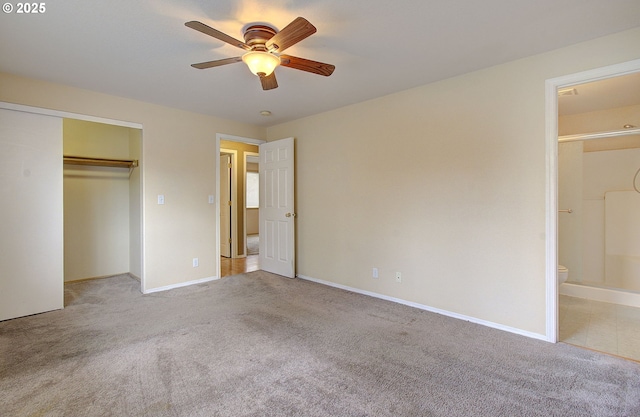 unfurnished bedroom featuring baseboards, a closet, ensuite bath, and light colored carpet