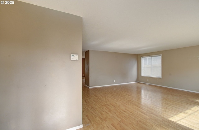 unfurnished room featuring light wood-type flooring and baseboards