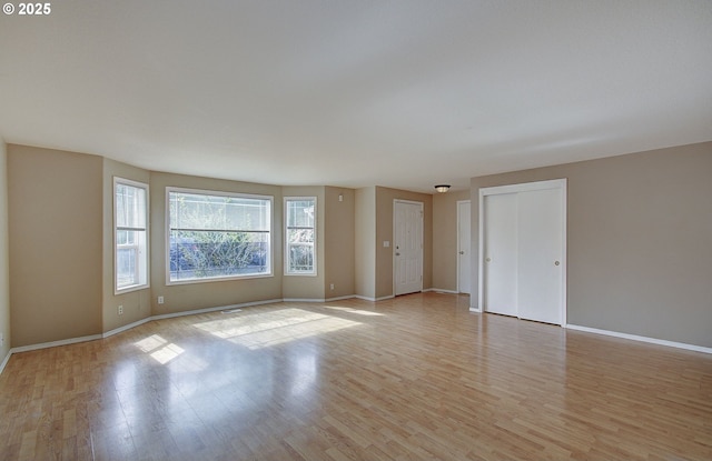 spare room with light wood-style flooring and baseboards