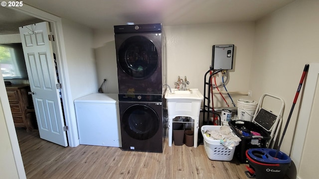 washroom with laundry area, wood finished floors, and stacked washer and dryer
