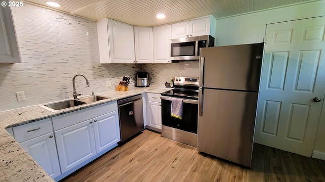 kitchen featuring a sink, stainless steel appliances, light wood-style floors, and white cabinets