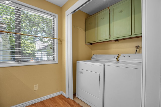 5786 SW 204th Pl, Beaverton, OR 97078 - laundry room with cabinet space, washer and clothes dryer, light wood finished floors, and baseboards