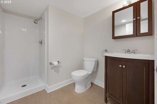 full bath featuring baseboards, vanity, toilet, and a shower stall