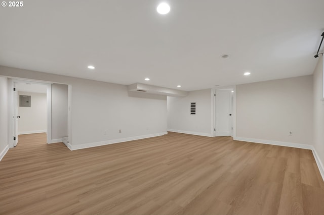 finished basement with baseboards, light wood-type flooring, and recessed lighting