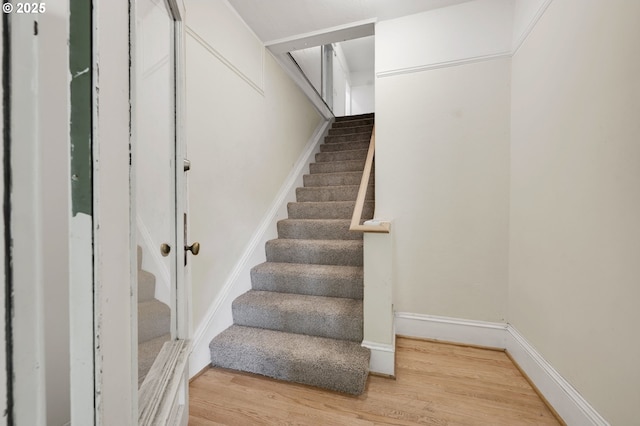 stairway featuring baseboards and wood finished floors