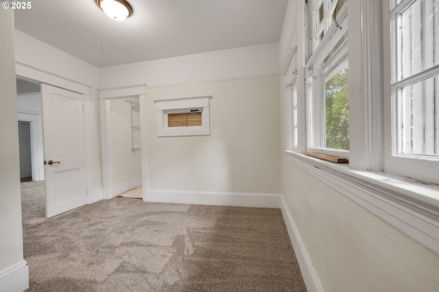 unfurnished room with baseboards and carpet