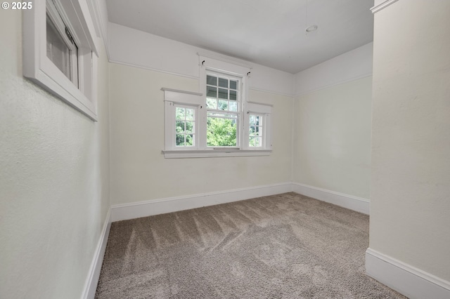 carpeted empty room featuring baseboards
