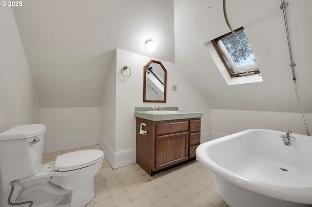 full bathroom with toilet, vaulted ceiling with skylight, vanity, tile patterned floors, and a freestanding bath
