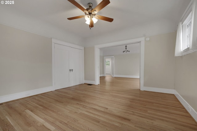 interior space with a ceiling fan, visible vents, baseboards, and light wood-style flooring