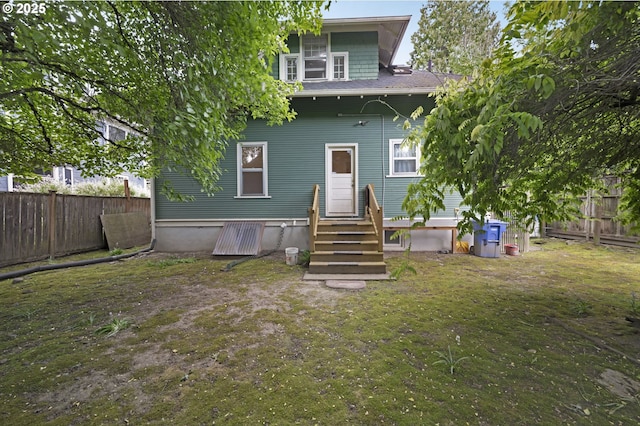 back of property featuring a fenced backyard, a lawn, entry steps, and central AC unit