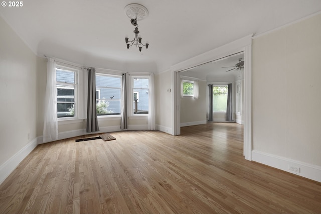 interior space featuring light wood finished floors, baseboards, and a notable chandelier