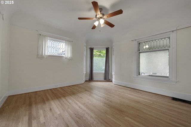 spare room with visible vents, light wood-style flooring, baseboards, and ceiling fan