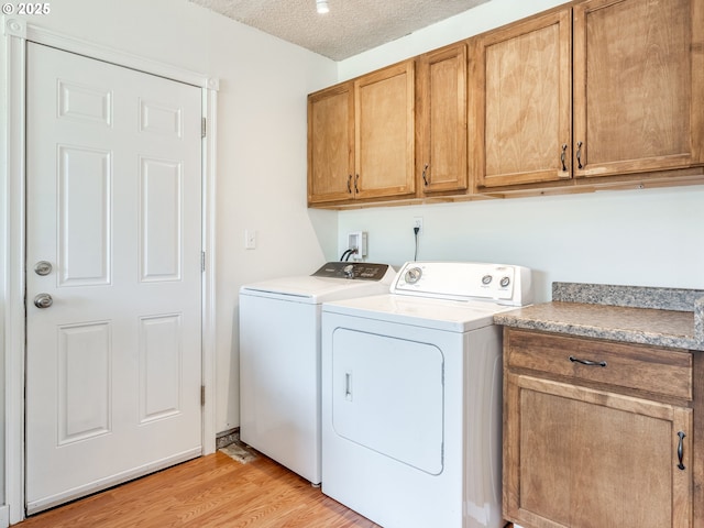 575 SE Centurion Ave, Gresham, OR 97080 - washroom with separate washer and dryer, cabinet space, light wood-style floors, and a textured ceiling