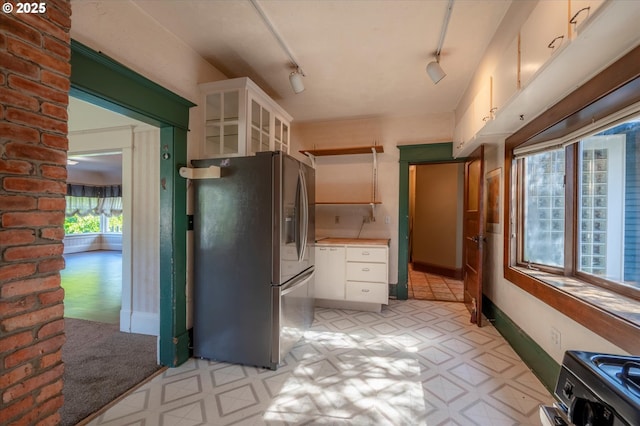 619 S 11th St, Coos Bay, OR 97420 - kitchen featuring stainless steel fridge, white cabinetry, light floors, glass insert cabinets, and track lighting