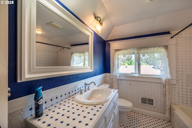 619 S 11th St, Coos Bay, OR 97420 - bathroom with vaulted ceiling, vanity, toilet, a wainscoted wall, and tile patterned floors