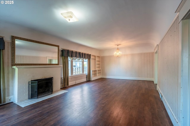 619 S 11th St, Coos Bay, OR 97420 - unfurnished living room featuring a chandelier, wood finished floors, and a brick fireplace
