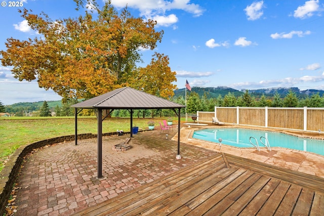 view of swimming pool featuring a gazebo, a mountain view, a patio, and a diving board
