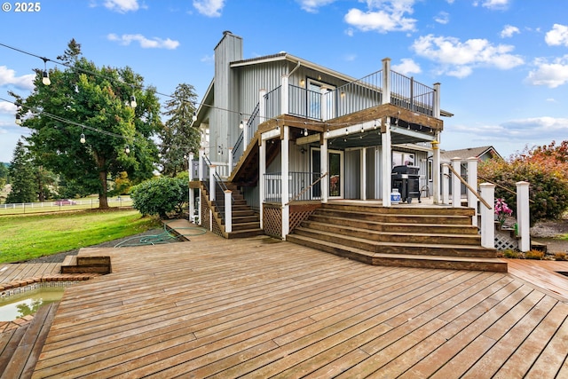back of house with a wooden deck, a chimney, stairs, and board and batten siding