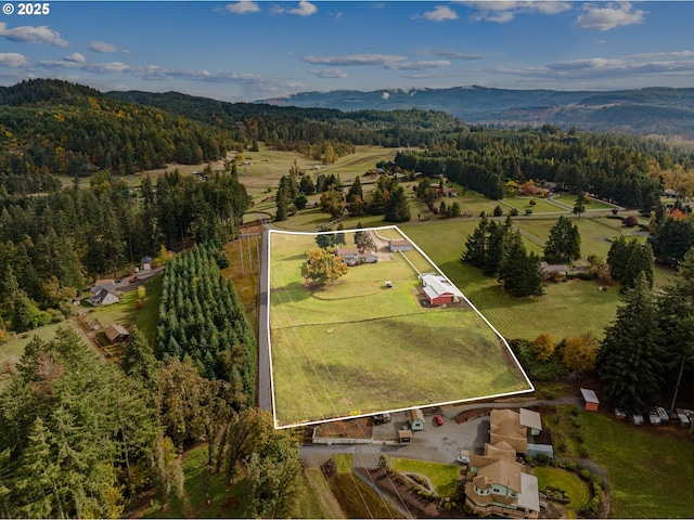aerial view of property and surrounding area with a forest, mountains, and property parcel outlined