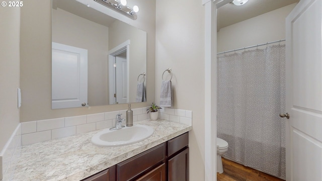 917 SE 9th Dr, Hermiston, OR 97838 - full bath with toilet, vanity, wood finished floors, curtained shower, and decorative backsplash