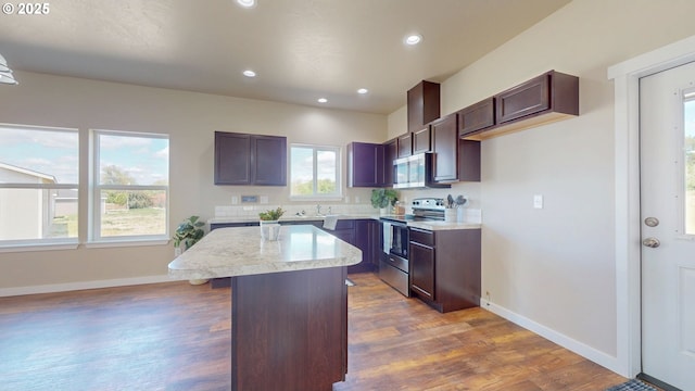 917 SE 9th Dr, Hermiston, OR 97838 - kitchen featuring stainless steel appliances, dark wood-style flooring, light countertops, a sink, and a center island