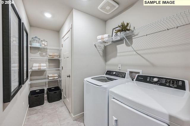 laundry area featuring light tile patterned floors and washer and dryer