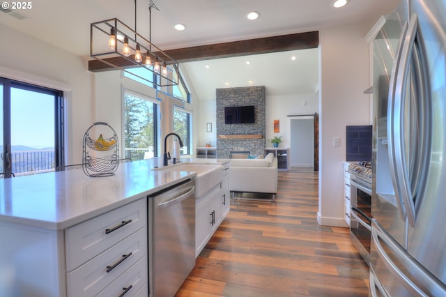 95660 Spirit Ridge Rd, Gold Beach, OR 97444 - kitchen with appliances with stainless steel finishes, open floor plan, white cabinetry, a fireplace, and light countertops