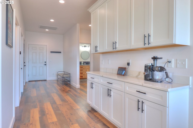 95660 Spirit Ridge Rd, Gold Beach, OR 97444 - kitchen with wood finished floors, white cabinets, recessed lighting, baseboards, and light stone countertops