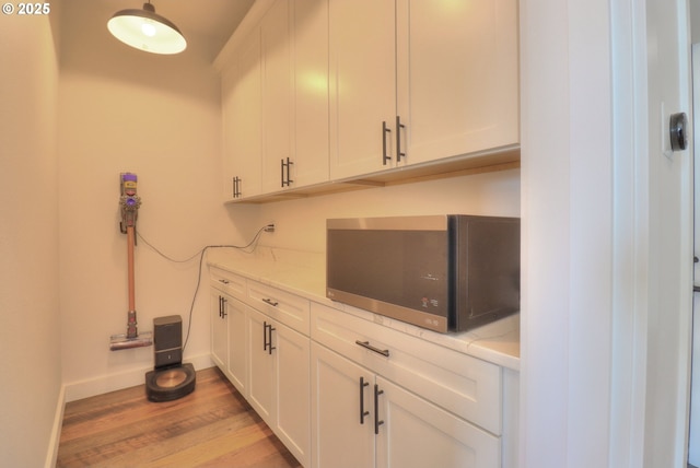 95660 Spirit Ridge Rd, Gold Beach, OR 97444 - bar featuring stainless steel microwave, light wood-style floors, and baseboards