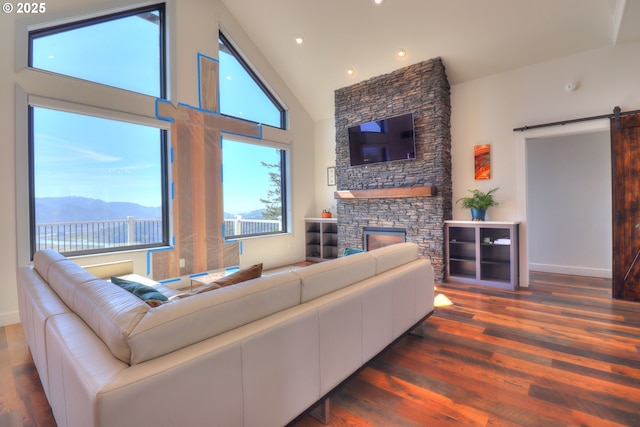 95660 Spirit Ridge Rd, Gold Beach, OR 97444 - living room with a barn door, high vaulted ceiling, wood finished floors, plenty of natural light, and a fireplace