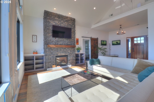 95660 Spirit Ridge Rd, Gold Beach, OR 97444 - living room featuring a barn door, wood finished floors, high vaulted ceiling, a stone fireplace, and recessed lighting